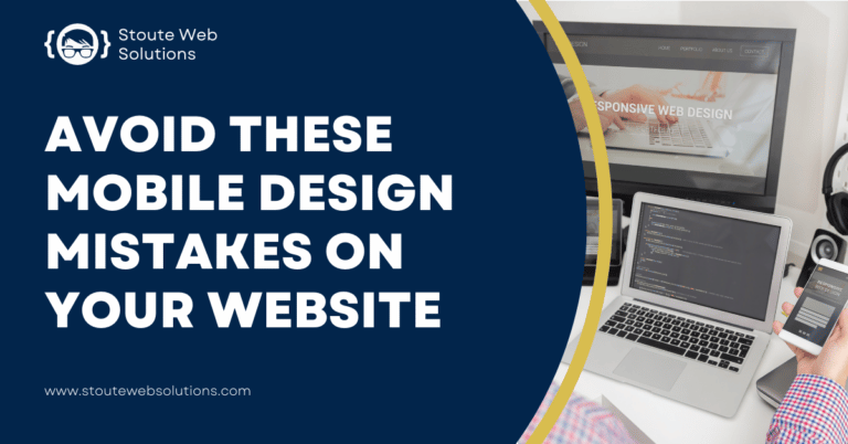 A guy with a phone in his hand sits in front of his table with a desktop monitor and a laptop on it.