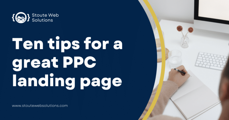 A guy is writing in a notebook on a white table.